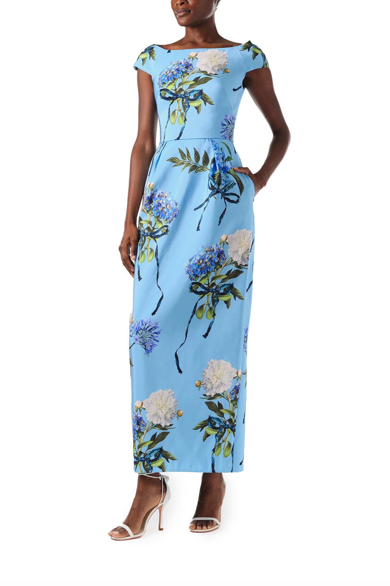 Monique Lhuillier Spring 2024 column gown with bateau neckline, cap sleeves and pockets in Sky Blue Hydrangea printed silk faille - angled.