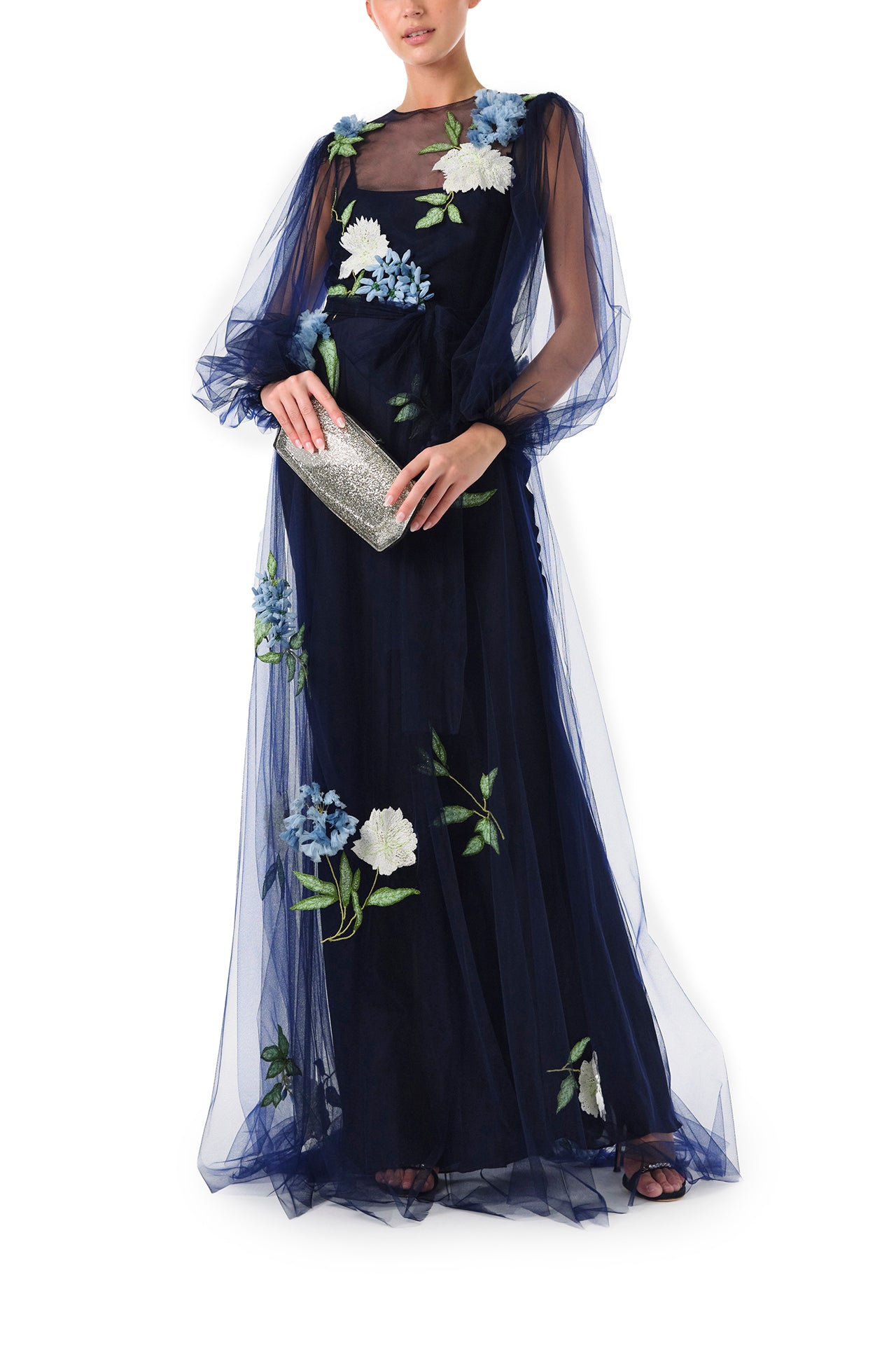 Monique Lhuillier Fall 2024 tulle gown with semi-sheer puff sleeves in Night Sky tulle and floral embroidery - front with handbag.