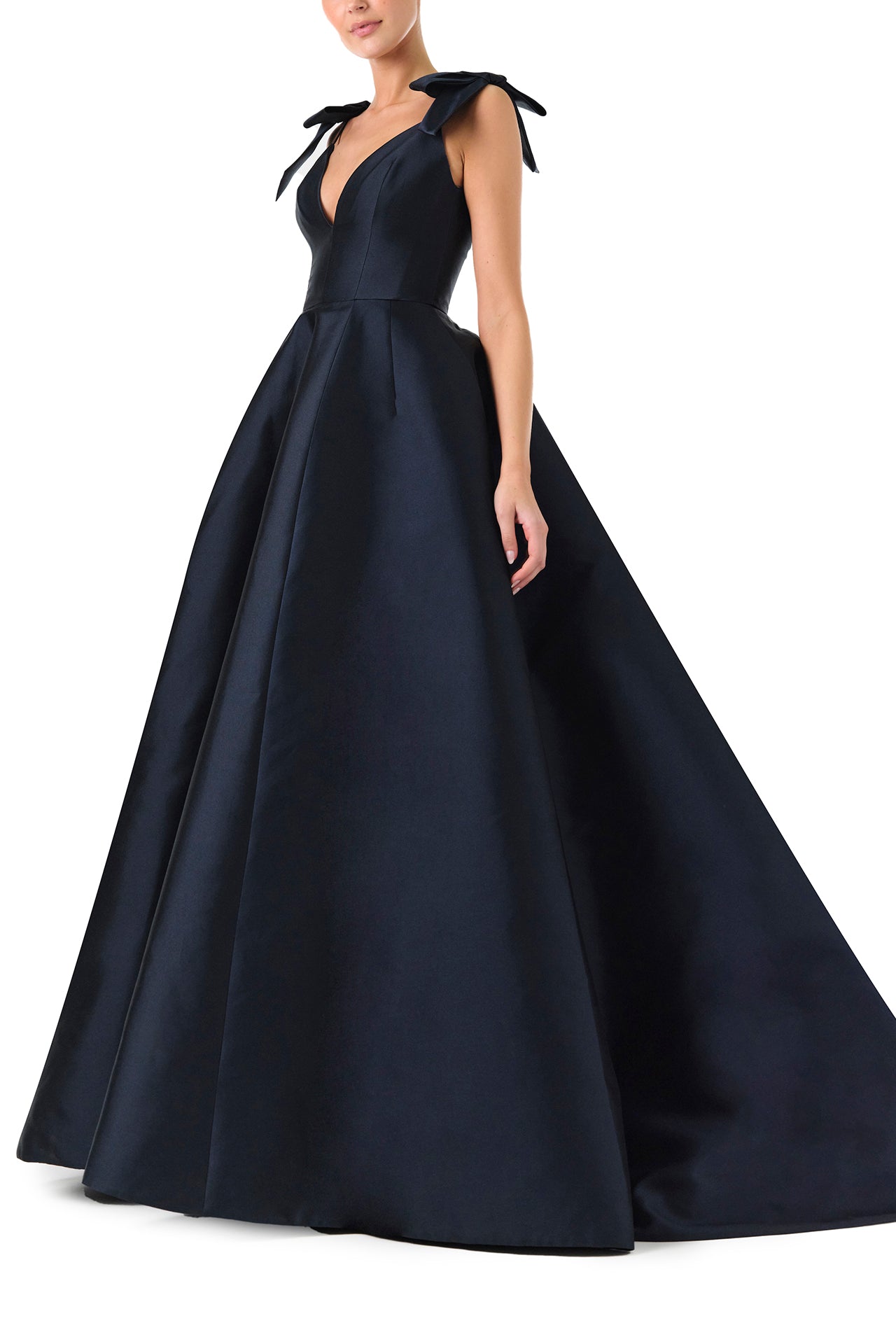 Monique Lhuillier Fall 2024 deep V-neck ball gown in navy mikado with full skirt and bow detail at shoulders - left side.