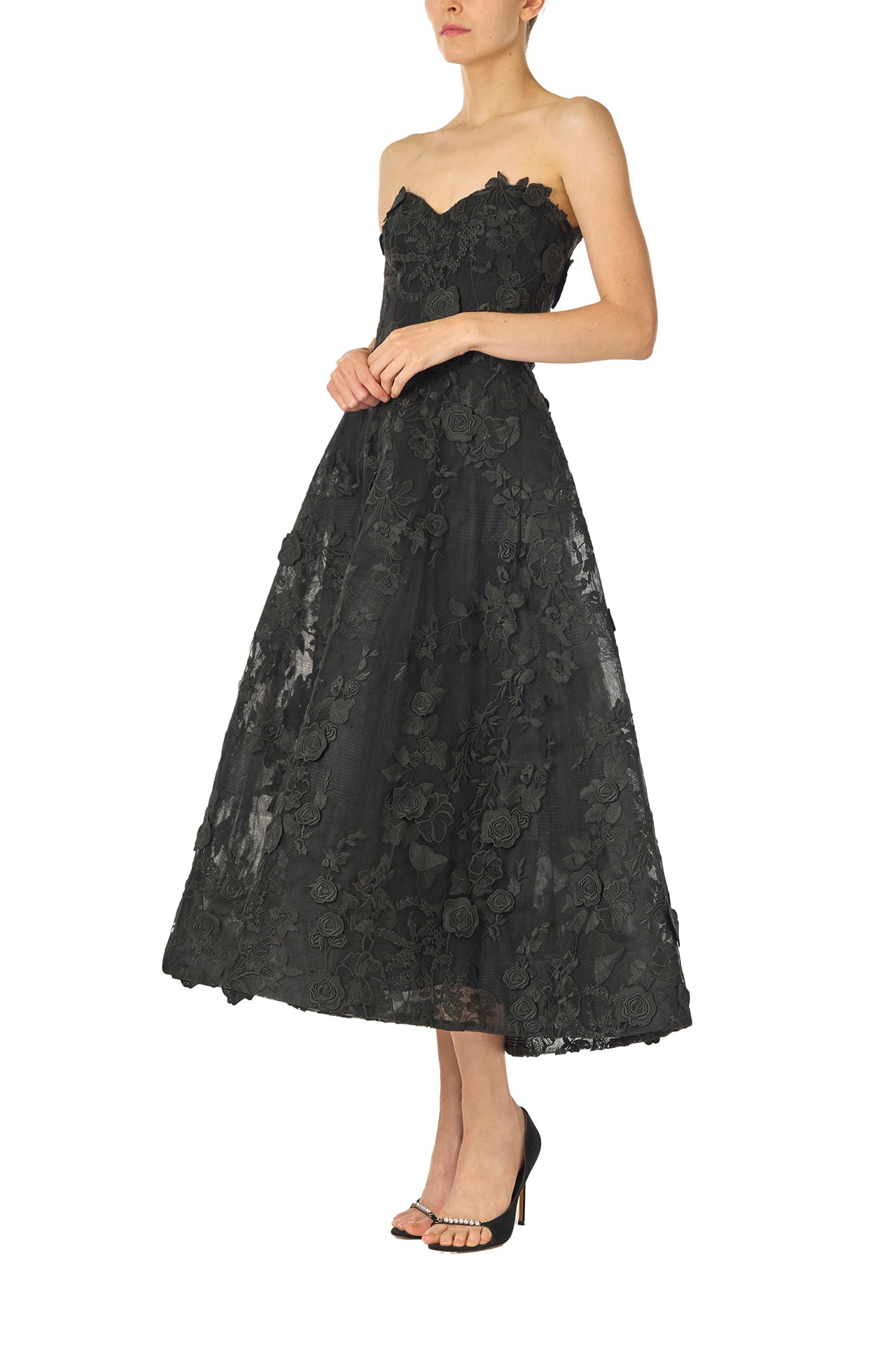 Monique Lhuillier Fall 2024 tea-length, strapless dress in noir 3D lace with full skirt and fitted sweetheart bodice - side.