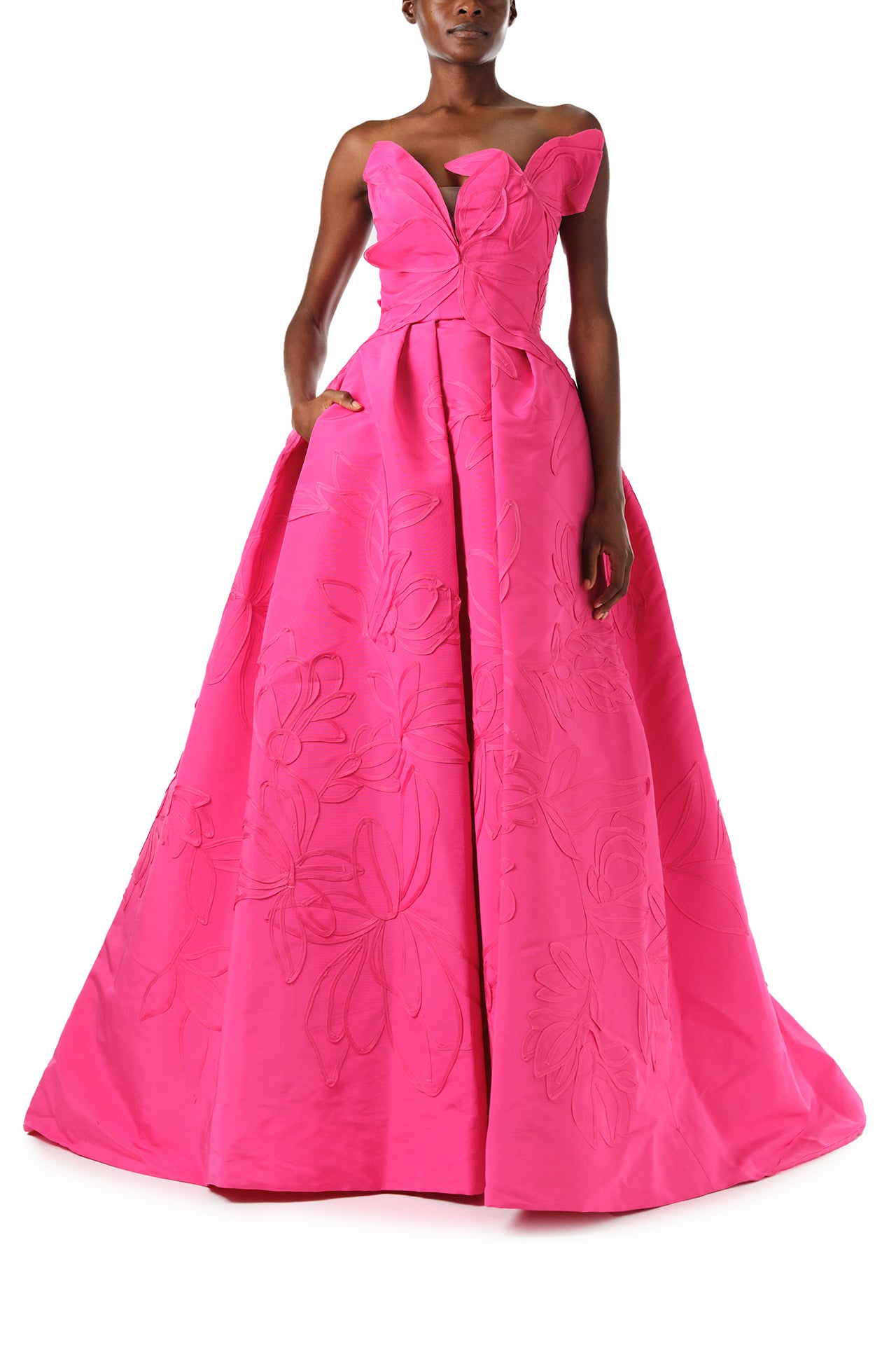 Monique Lhuillier Fall 2024 strapless, a-line ballgown in fuchsia floral embossed faille with draped asymmetrical bodice and full pleated skirt - front pockets.