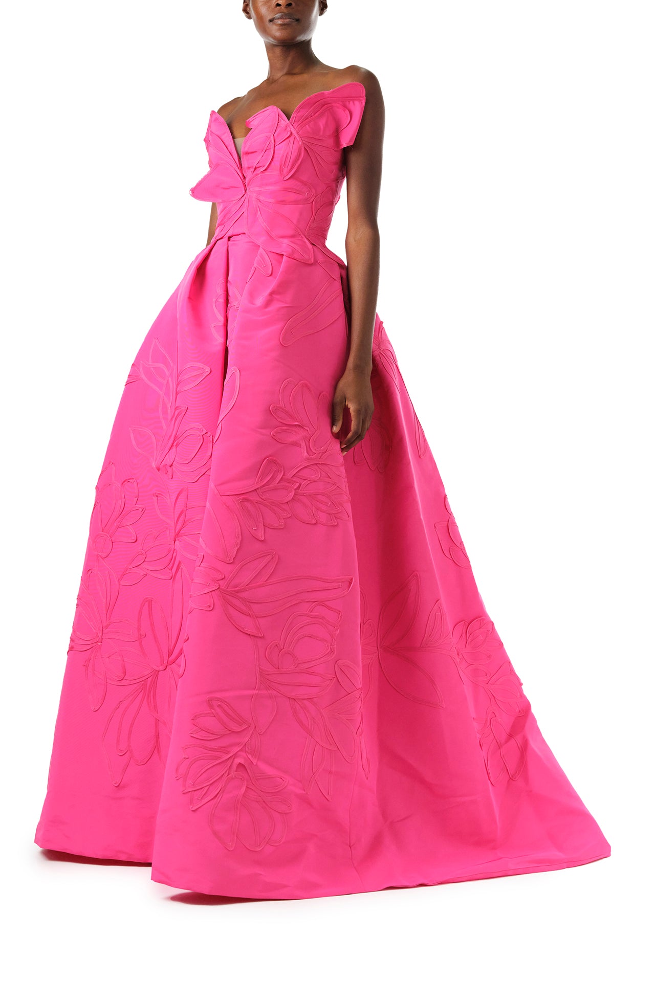 Monique Lhuillier Fall 2024 strapless, a-line ballgown in fuchsia floral embossed faille with draped asymmetrical bodice and full pleated skirt - side.