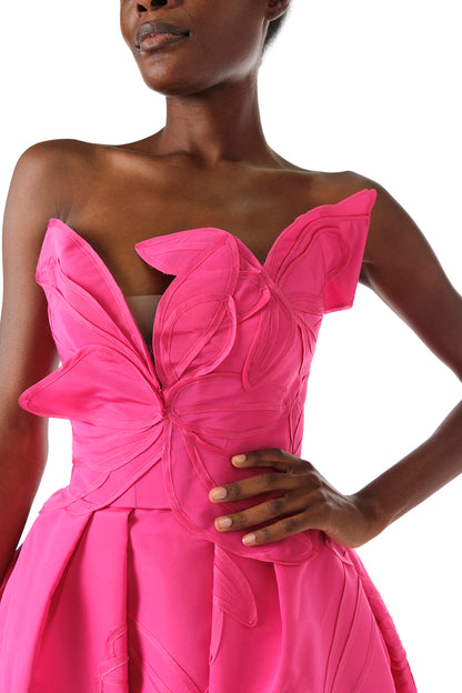 Monique Lhuillier Fall 2024 strapless, a-line ballgown in fuchsia floral embossed faille with draped asymmetrical bodice and full pleated skirt - bodice detail.