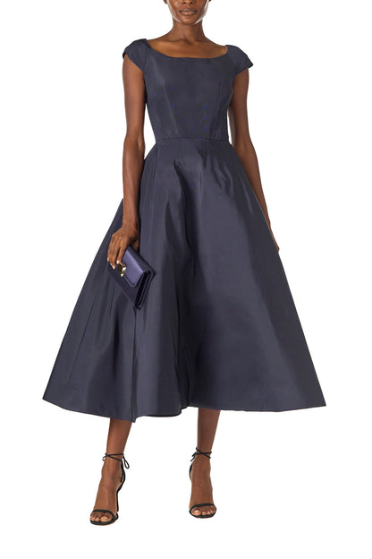 Monique Lhuillier Fall 2024 Bateau neck, cap sleeve dress with full tea length skirt in night sky silk faille - front with Delphine satin clutch.