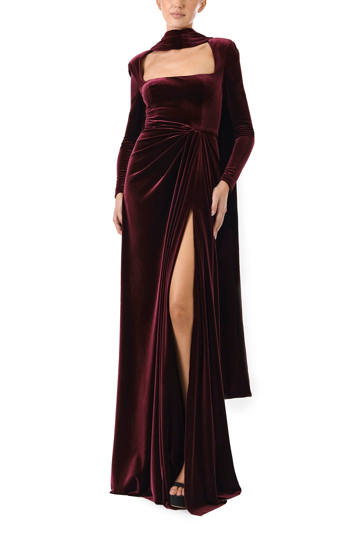Monique Lhuillier Fall 2024 Long sleeve gown with square neckline, front skirt draping and detached neck scarf in Merlot colored stretch velour - front.