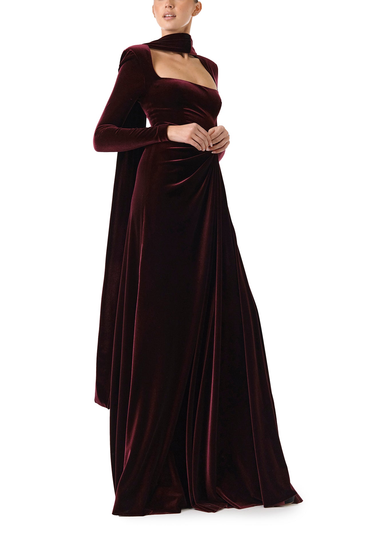 Monique Lhuillier Fall 2024 Long sleeve gown with square neckline, front skirt draping and detached neck scarf in Merlot colored stretch velour - right side.