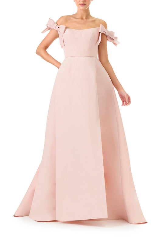 Monique Lhuillier Fall 2024 off the shoulder bow sleeve gown in pale blush faille with full skirt and high leg slit - front.