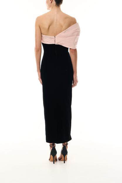 Monique Lhuillier Fall 2024 black velvet sheath dress with pale blush off the shoulder drapeda symmetric twist detail at neckline - back.
