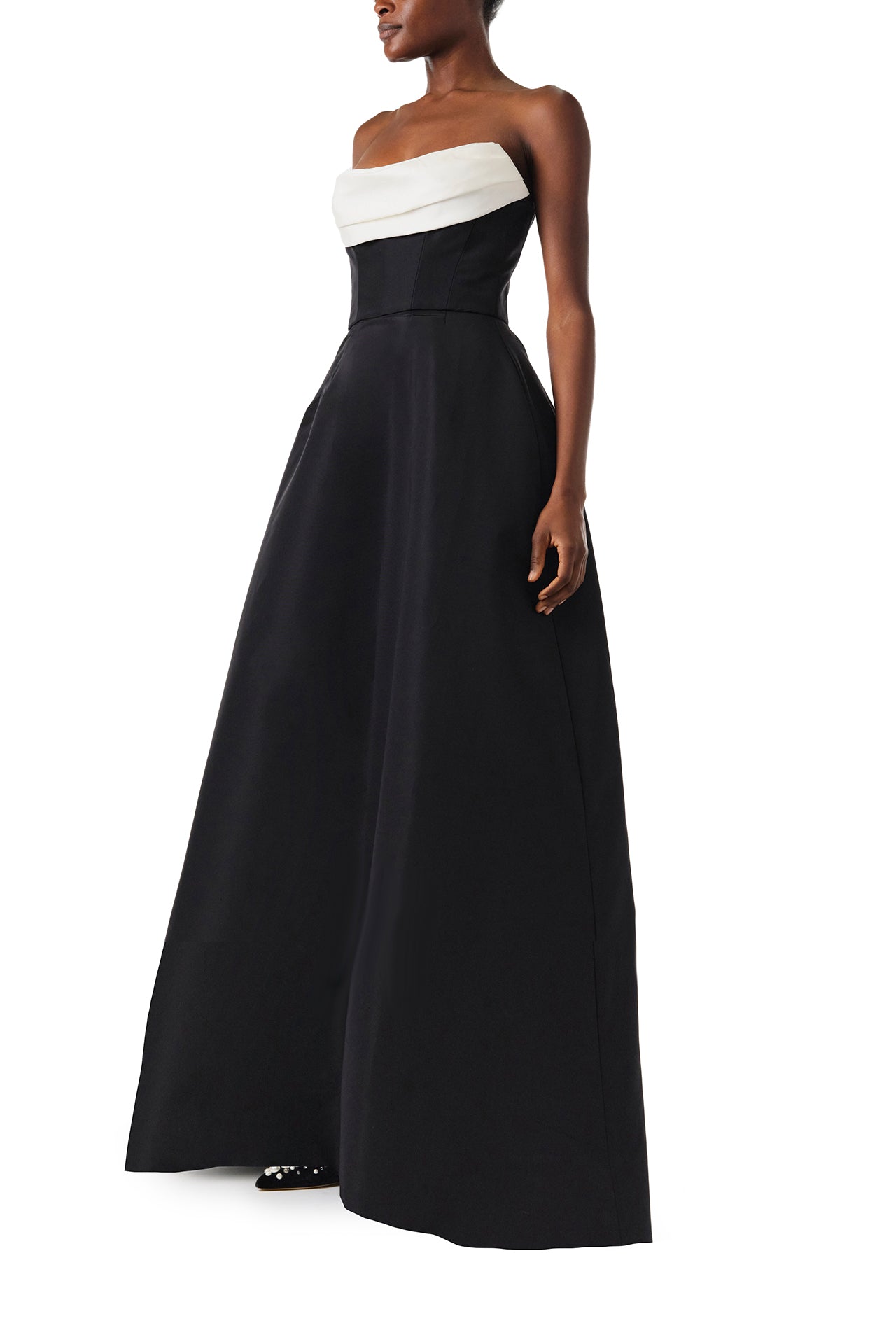 Monique Lhuillier Fall 2024 strapless ball gown with front-draped, contrasting neckline in noir/silk white faille fabric - left side.