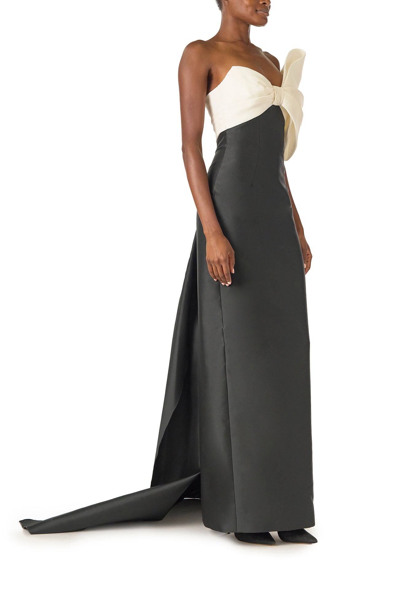 Monique Lhuillier Spring 2025 Strapless column gown with asymmetric draped bow neckline and pleated back train in Noir + Silk White Mikado - right side.
