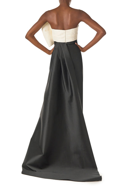 Monique Lhuillier Spring 2025 Strapless column gown with asymmetric draped bow neckline and pleated back train in Noir + Silk White Mikado - back.