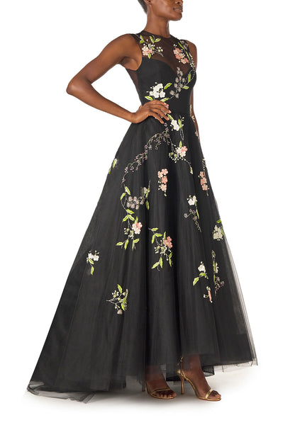 Monique Lhuillier Spring 2025 Sleeveless, noir tulle gown with floral embroidery and slight high-low hem - right side.