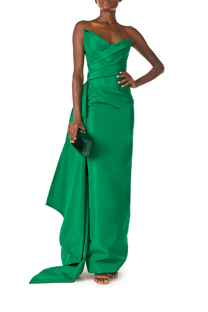 Monique Lhuillier Spring 2025 Strapless column gown with asymmetric draped neckline and sweeping side train in grass green faille fabric - front with Dasha bag.