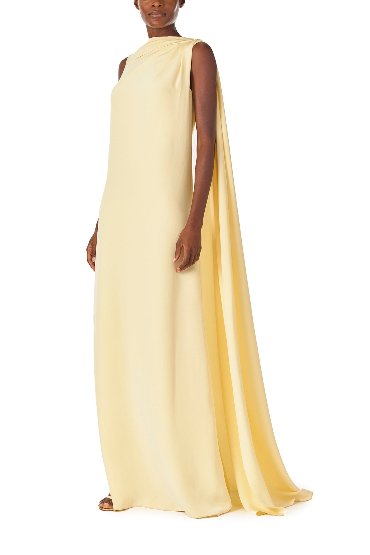 Monique Lhuillier Spring 2025 draped shoulder caftan gown with integral cape and side slit in limoncello yellow - left side.
