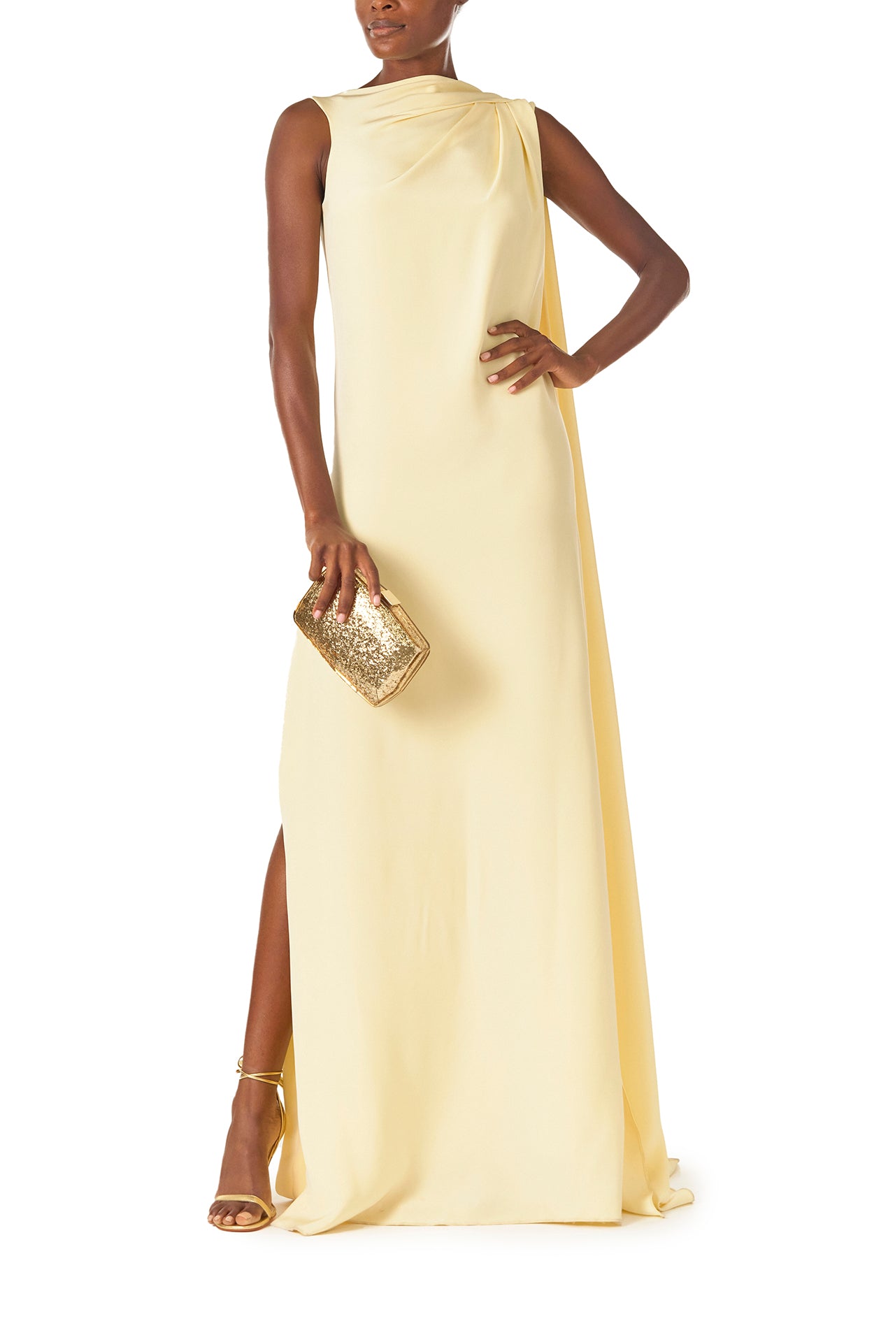 Monique Lhuillier Spring 2025 draped shoulder caftan gown with integral cape and side slit in limoncello yellow - front with Dasha gold handbag.