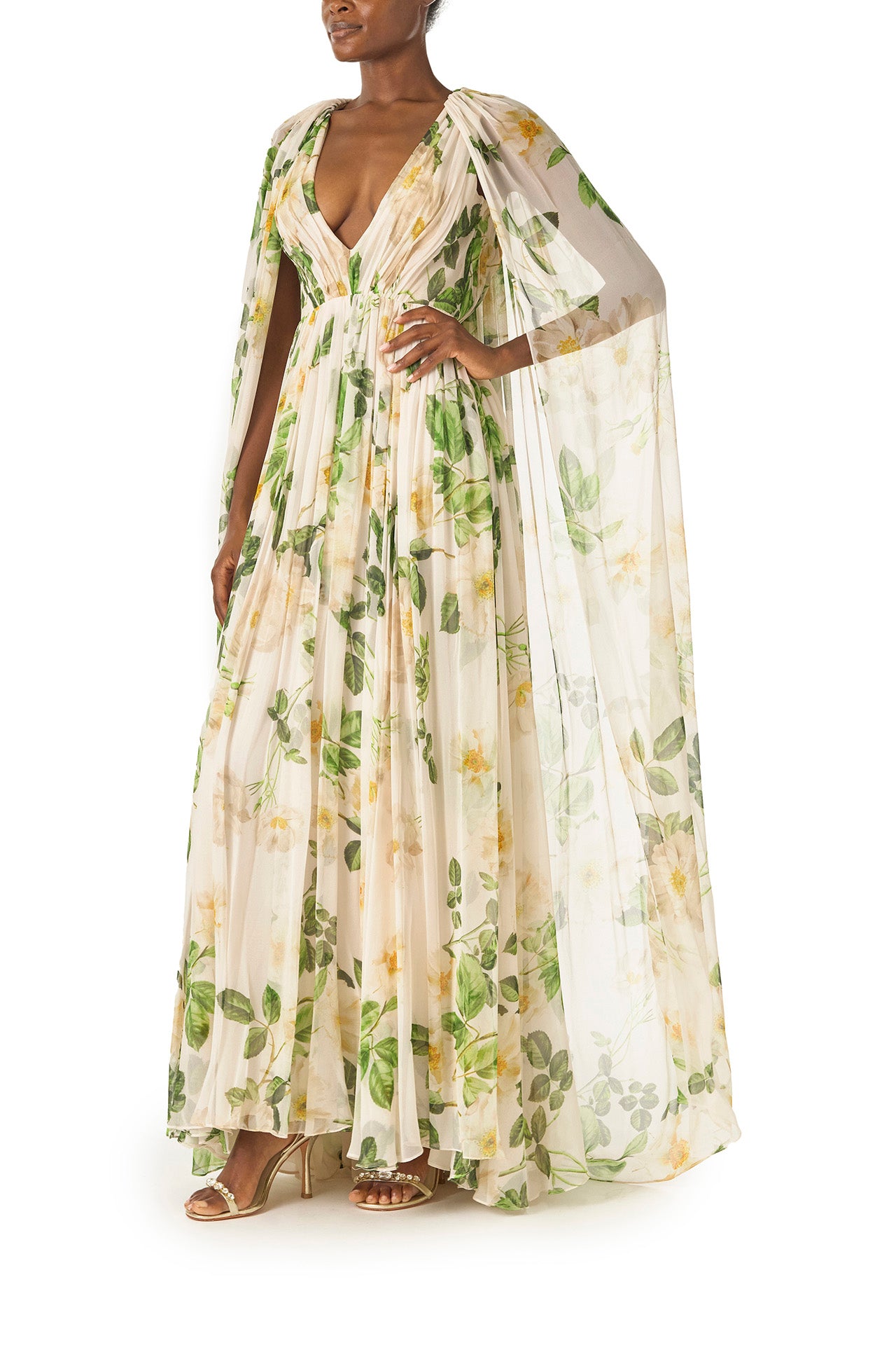 Monique Lhuillier Spring 2025 Draped, v-neck gown in Rose Printed Chiffon with low back and flowing, integral cape - left side.