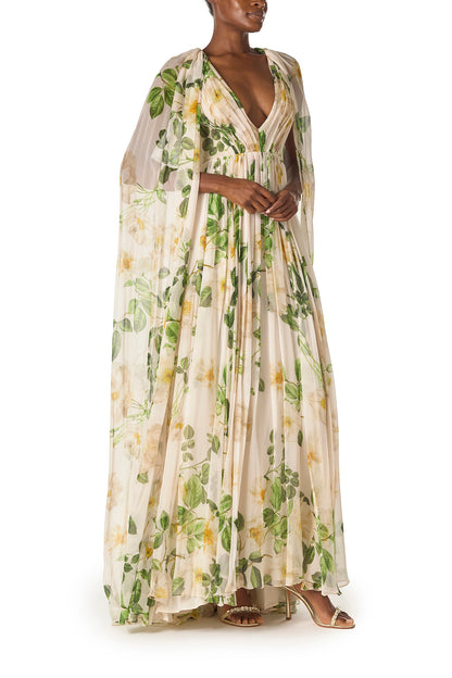 Monique Lhuillier Spring 2025 Draped, v-neck gown in Rose Printed Chiffon with low back and flowing, integral cape - right side.