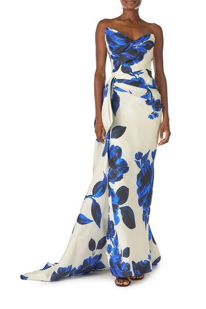 Monique Lhuillier Spring 2025 Strapless, column gown with asymmetric neckline, tufted draping and sweeping side train in Nautical Blue Floral printed gazar - front