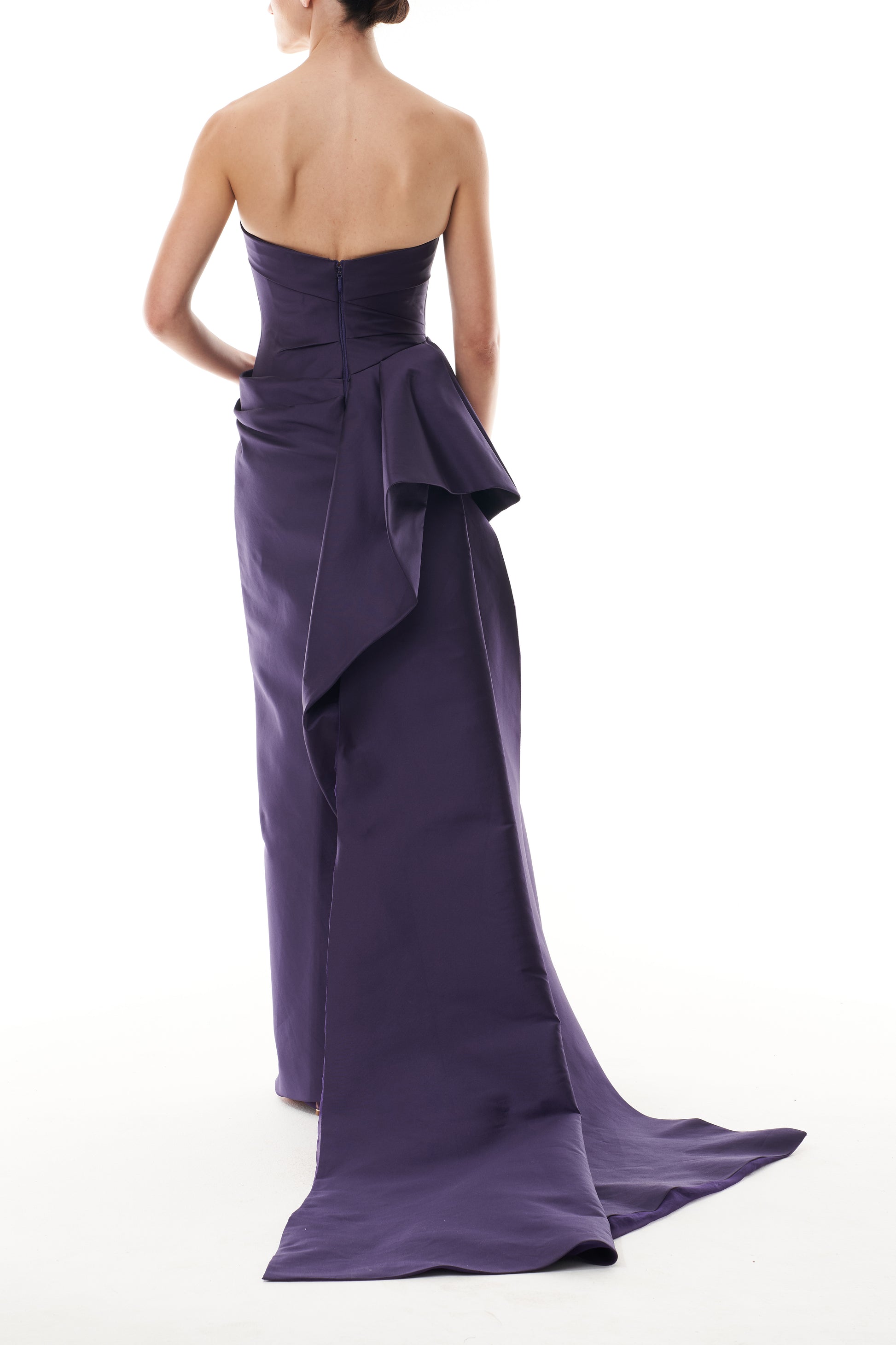 Monique Lhuillier Fall 2025 floor length gown with draped bodice and front leg slit in violet mikado fabric - back.
