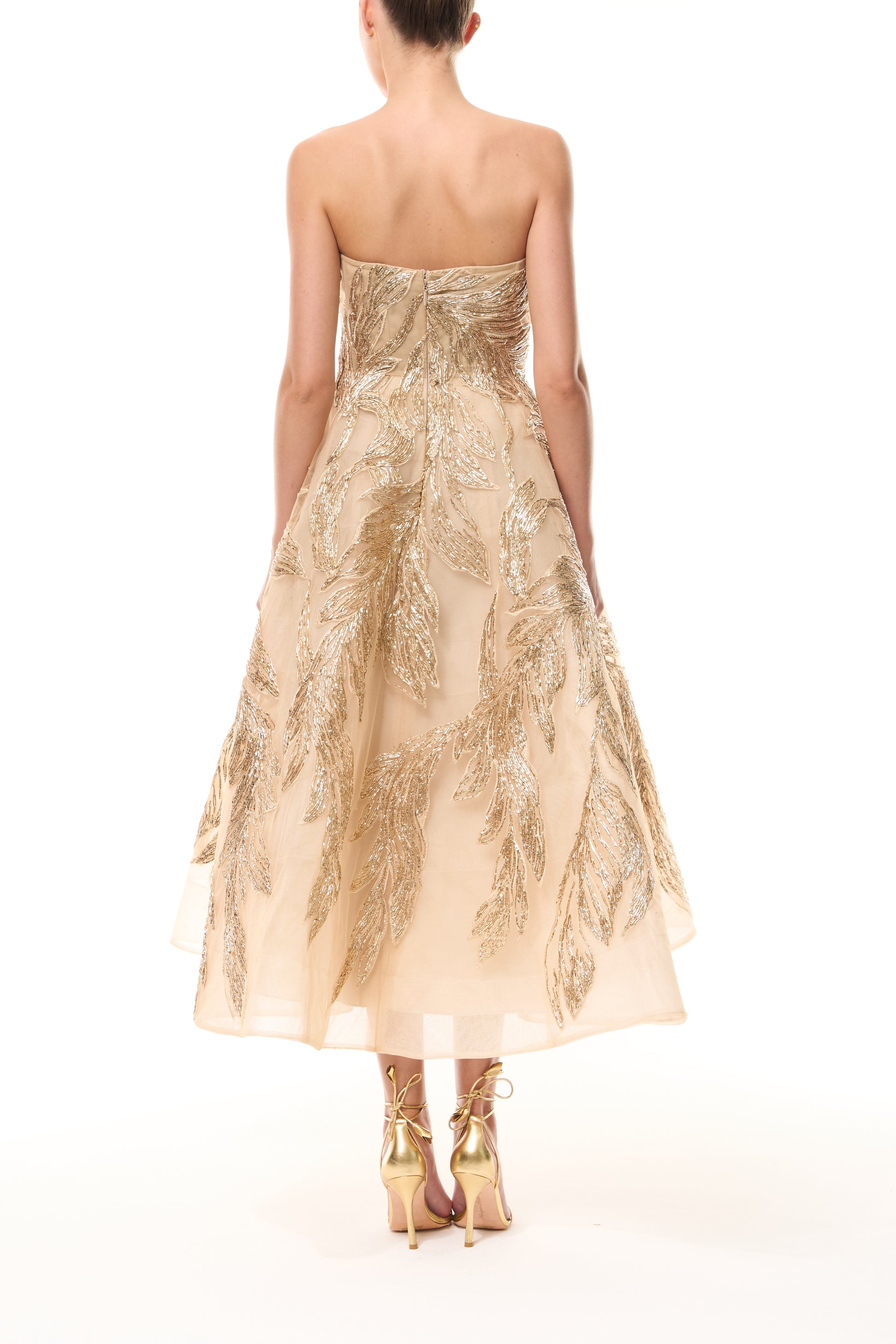 Monique Lhuillier Fall 2025 strapless dress with tea-length skirt and sweetheart neckline in gold feather embroidery - back.