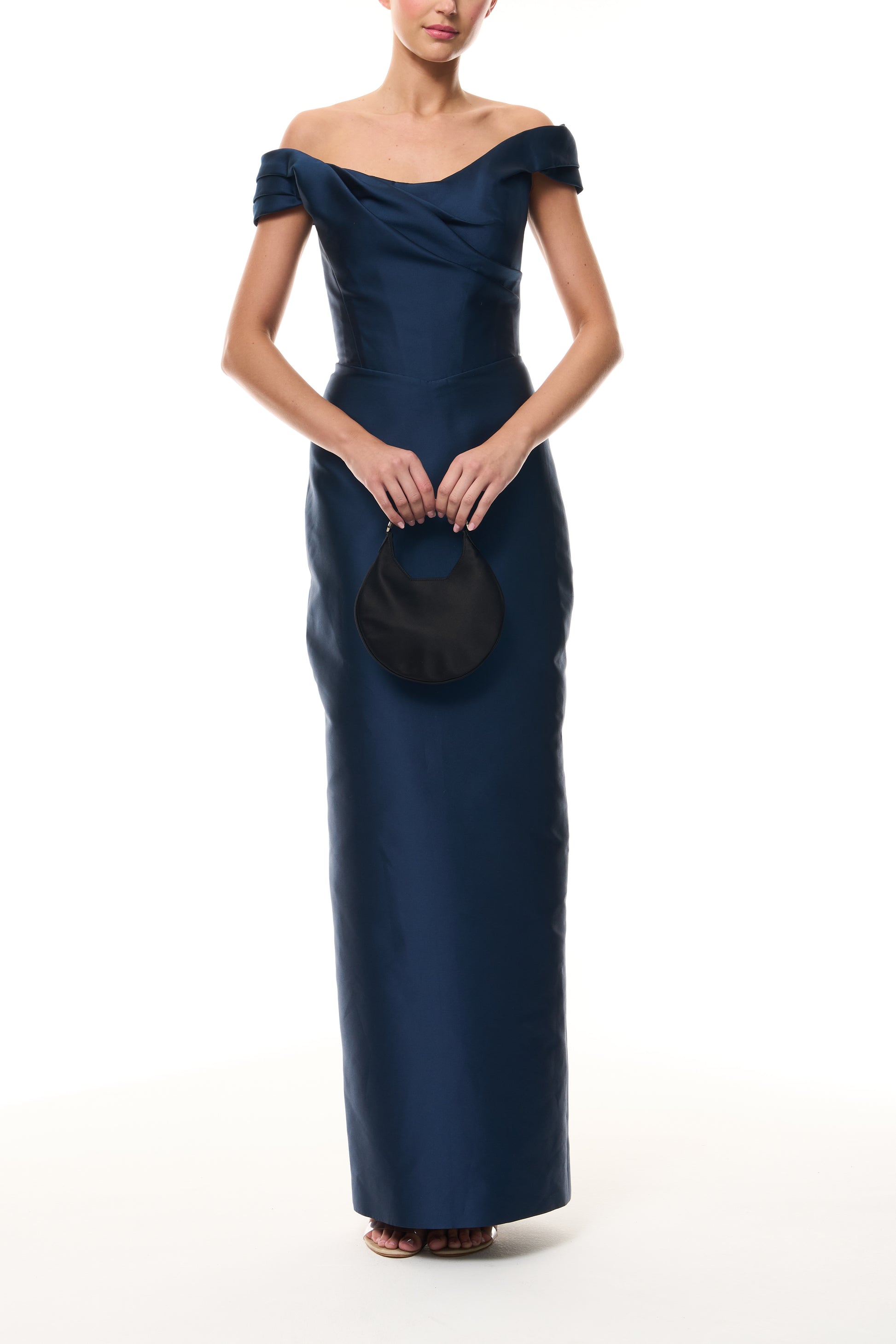 Monique Lhuillier Fall 2025 Ocean Mikado Off-the-shoulder draped bodice column gown - front with Noir Demi Evening Bag.