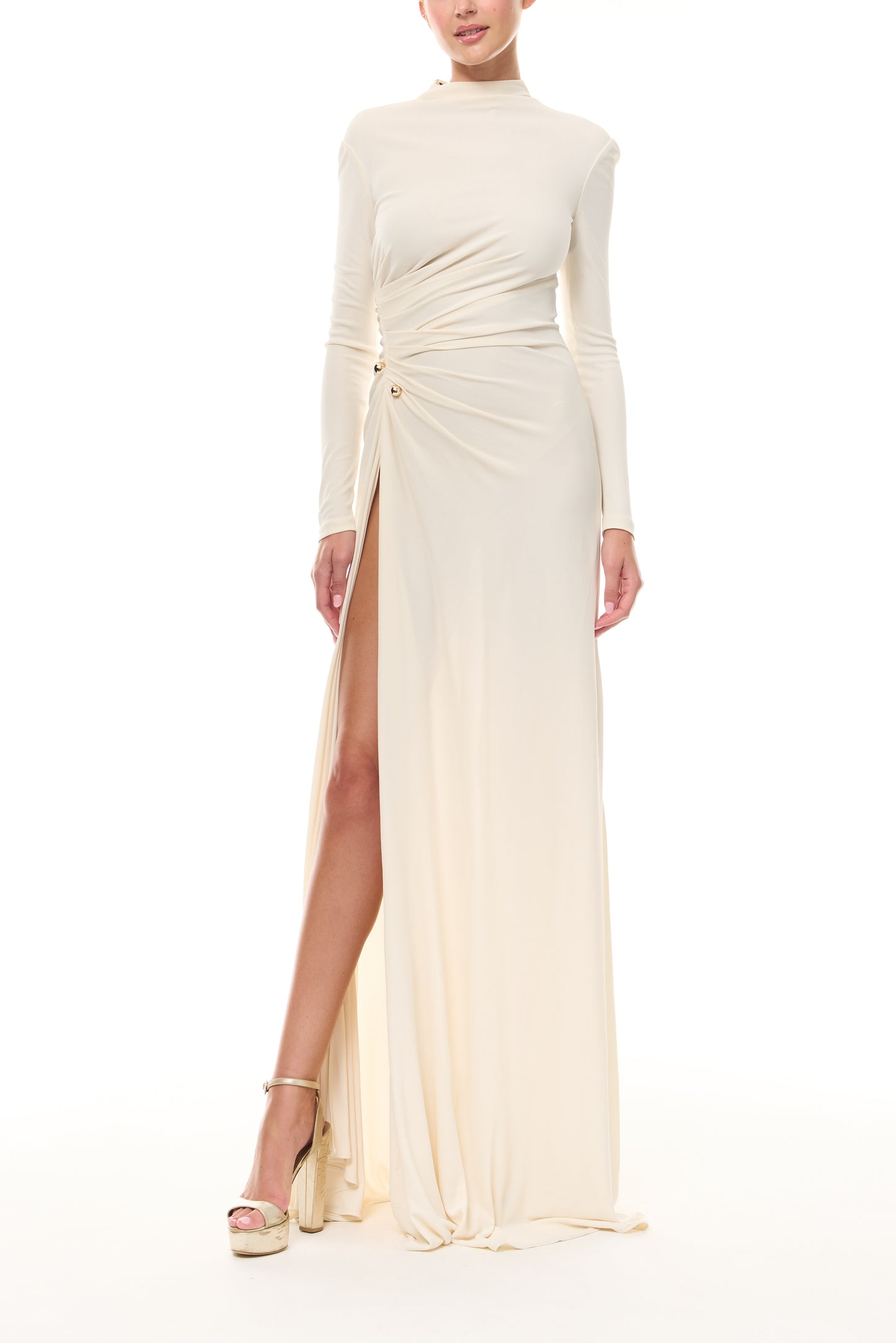 Monique Lhuillier Spring 2026 Ivory crepe jersey high neck long sleeved draped gown with slit and gold ball piercing - front.