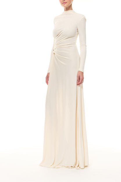 Monique Lhuillier Spring 2026 Ivory crepe jersey high neck long sleeved draped gown with slit and gold ball piercing - side. 