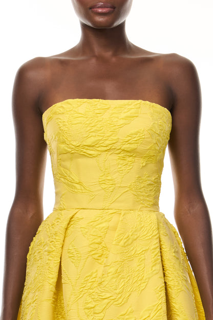 Monique Lhuillier Spring 2026- wearing Buttercup Botanical Matelassé strapless draped gown with slit - fabric.