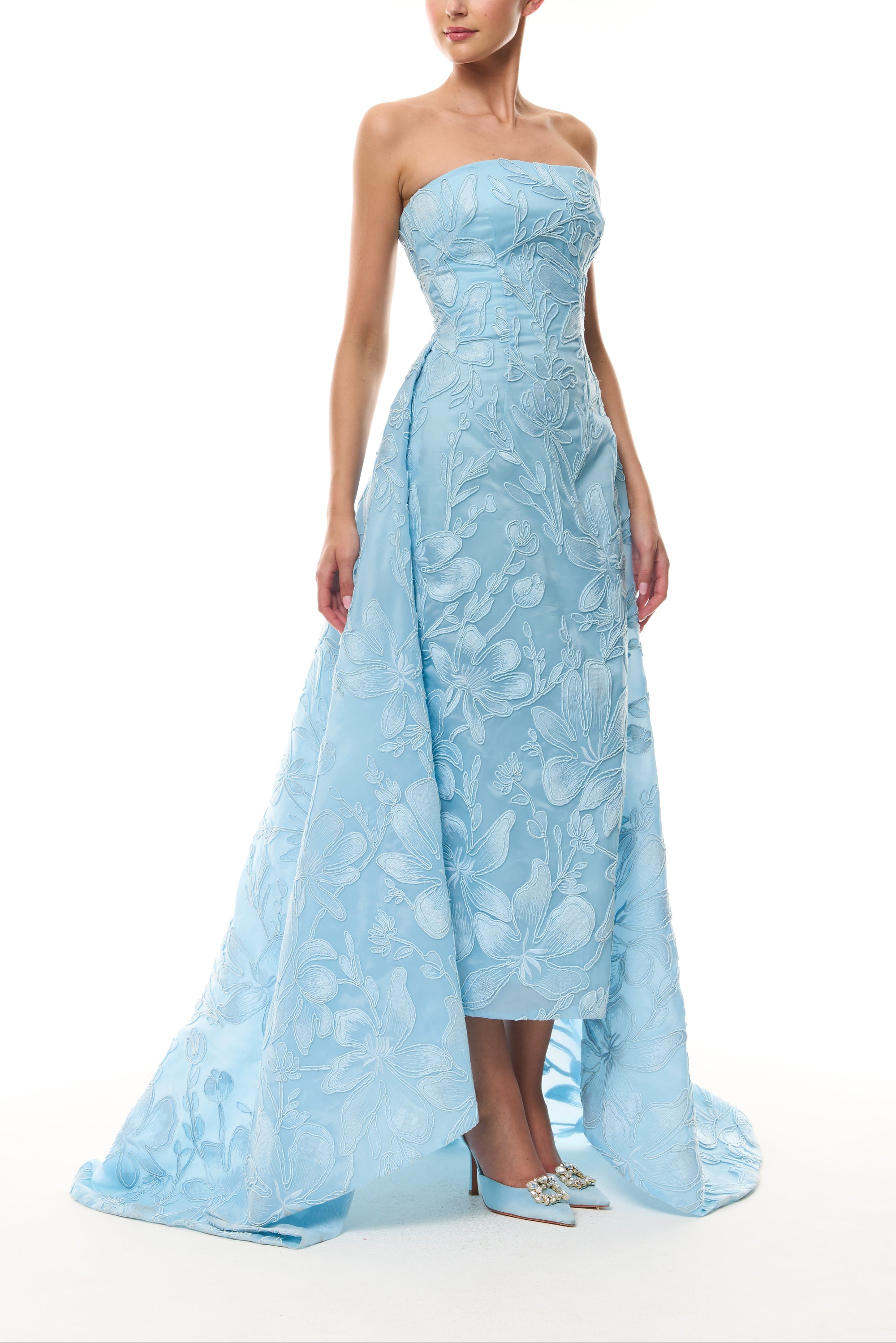 Monique Lhuillier Spring 2026 Plumeria Floral Corded Organza Strapless tea - length column gown with train - side.