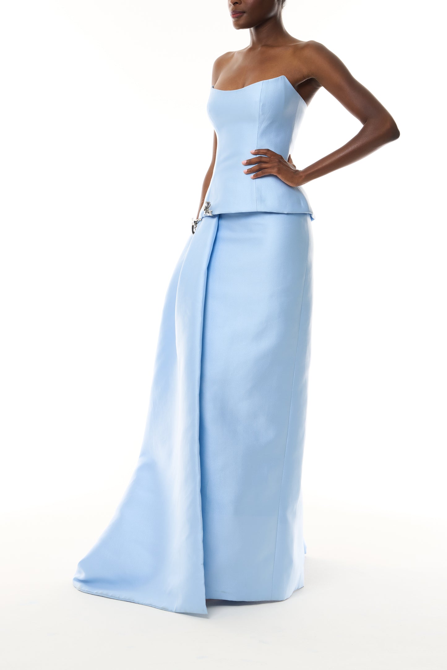 Monique Lhuillier Fall 2026 Pale Blue Mikado Piqué strapless dropped waist peplum gown with column skirt, side train and silver floral embellishment - side.