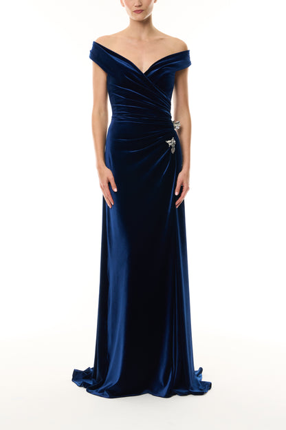 Monique Lhuillier Fall 2026 Navy off-the-shoulder stretch velour draped floor length gown with slit and silver floral embellishment - front. 