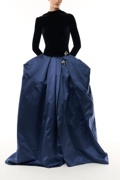 Monique Lhuillier Fall 2026 Noir and Navy Velvet and Duchess Satin long sleeve high neck pleated ballgown with silver floral embellishment - front. 
