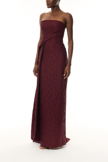 Monique Lhuillier Fall 2026 Rhubarb Jacquard strapless draped column gown with side train - side.