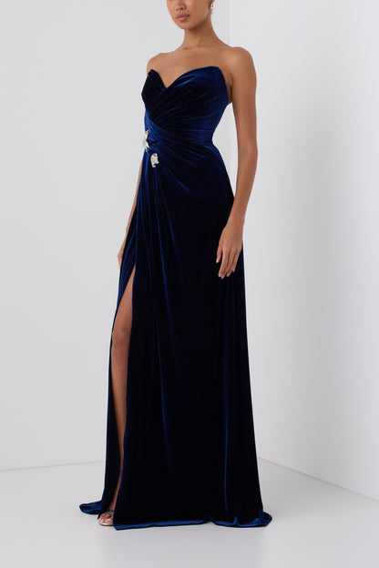 Monique Lhuillier Fall 2026 Navy stretch velour draped gown with slit and silver floral embellishment -side. 