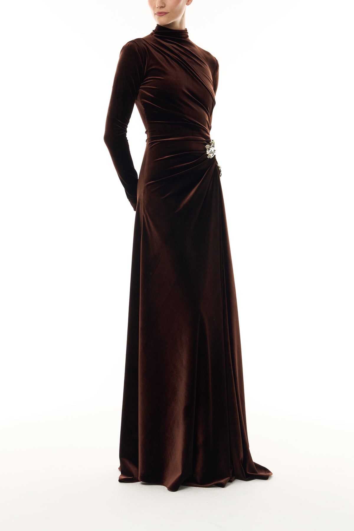 Monique Lhuillier Fall 2026 Café brown stretch velour high neck long sleeve gown with slit and gold floral embellishment - side.