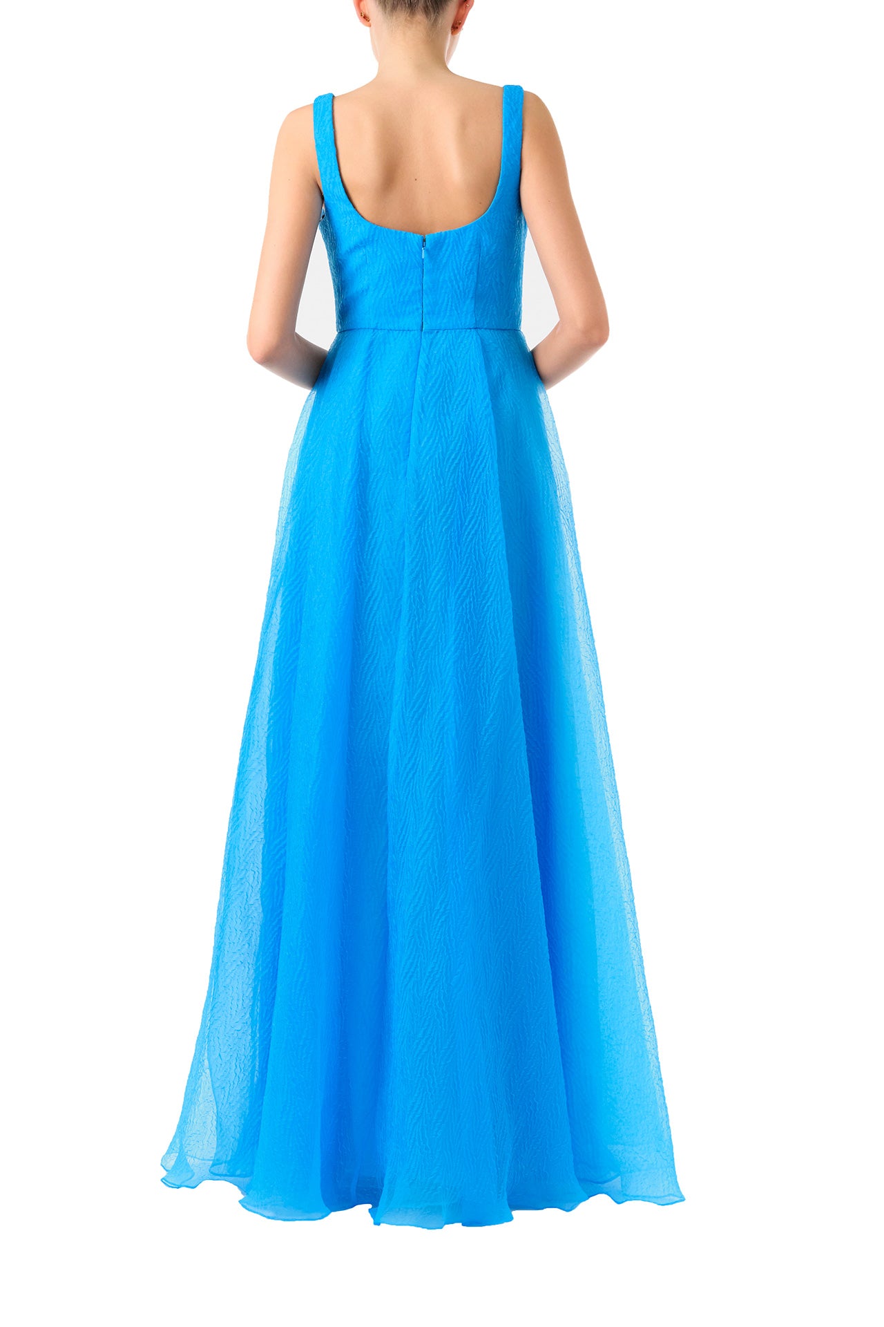 ML Monique Lhuillier 2024 scoop neck long dress with asymmetrical pleated front skirt and slit in Cyan Blue textured organza - back.