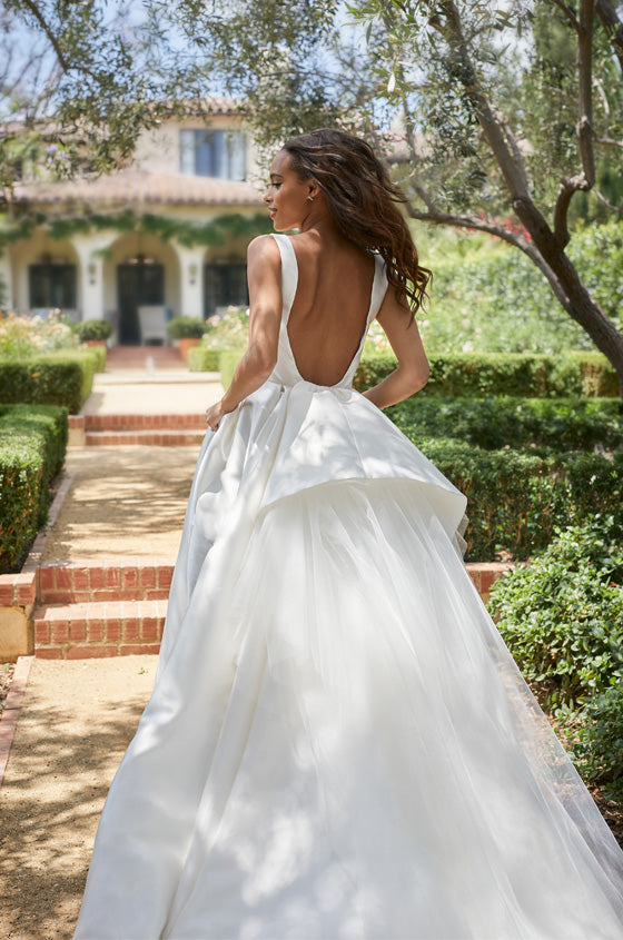 Model in open-back white satin a-line gown with tulle detail