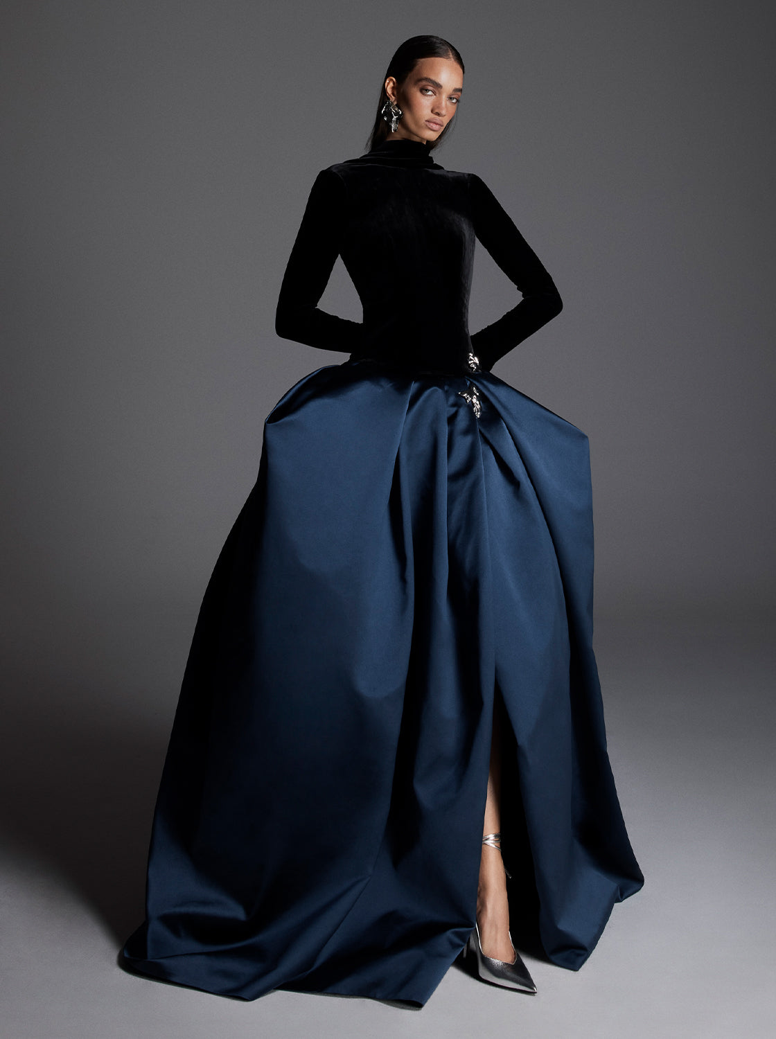 Monique Lhuillier Fall 2026 Noir/Navy velvet and duchesse satin long sleeve dropped waist ballgown with floral  embellishment- lookbook.