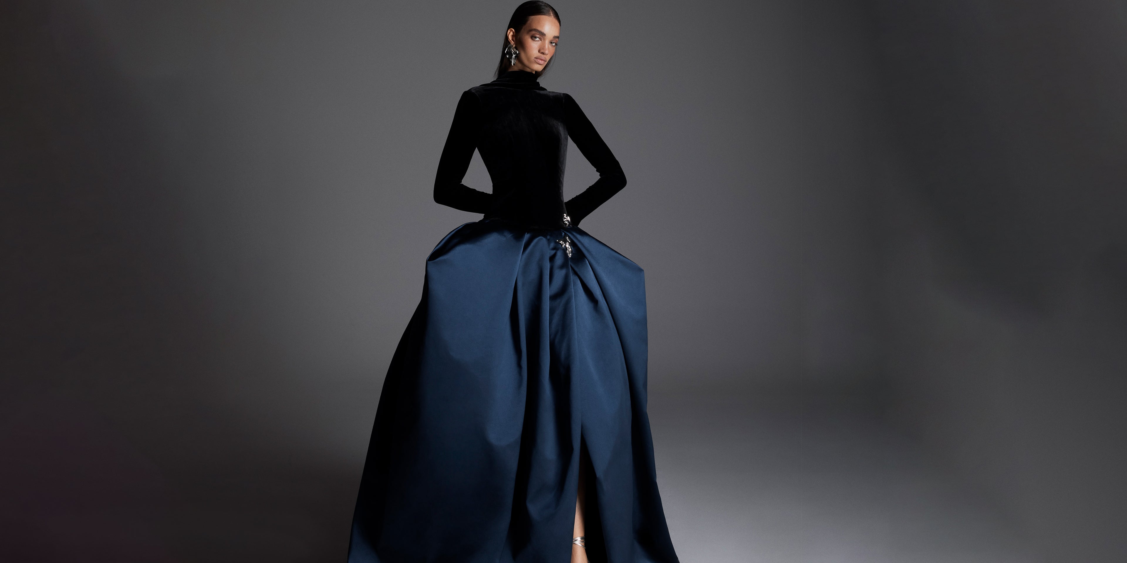 Monique Lhuillier Fall 2026 Noir/Navy velvet and duchesse satin long sleeve dropped waist ballgown with floral  embellishment- lookbook.