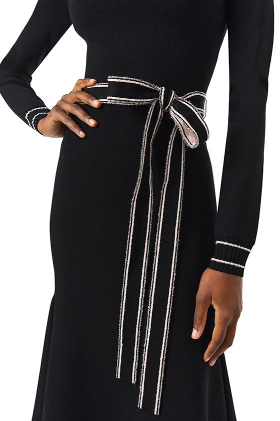 Monique Lhuillier Fall 2024 black knit long sleeve dress with handkerchief hem and self-tie belt - detail.