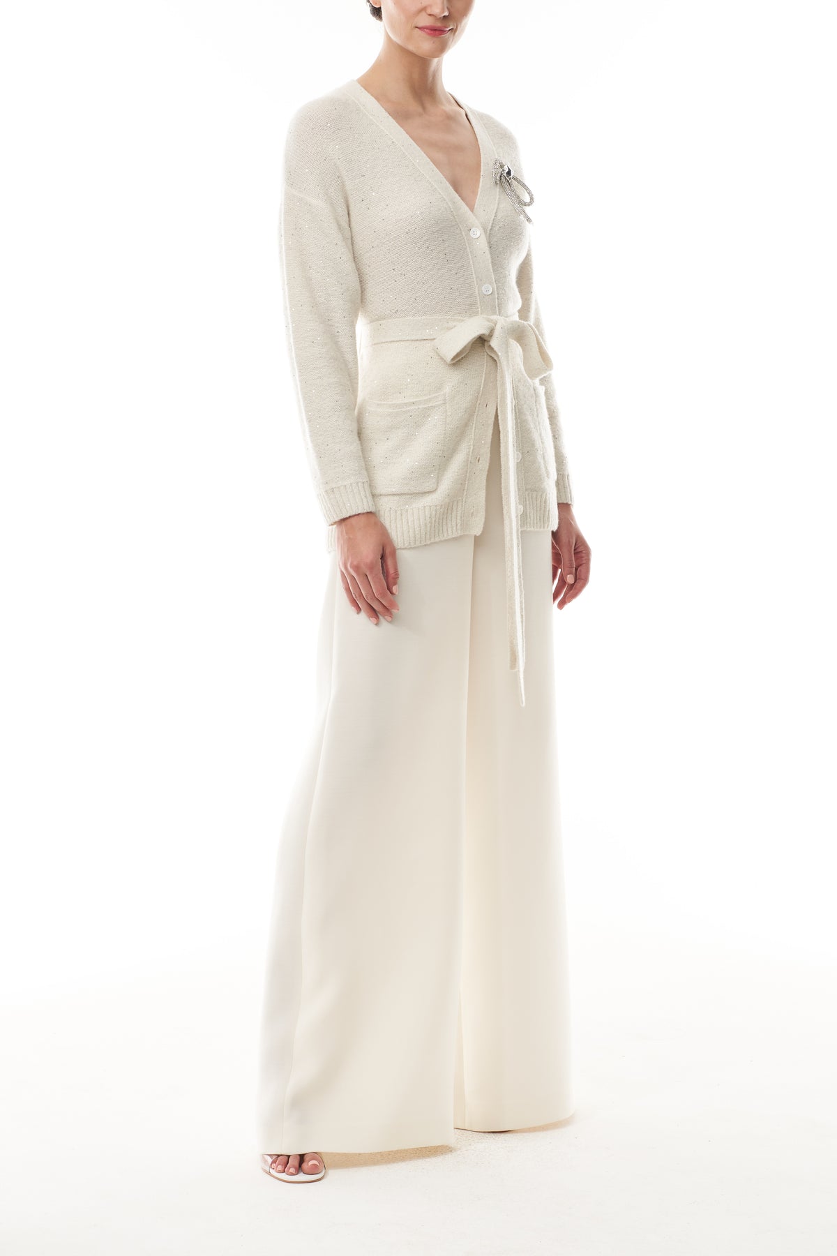 Monique Lhuillier Fall 2025 long sleeve cardigan in ivory sequin cashmere with bow brooch and self-tie belt - side.