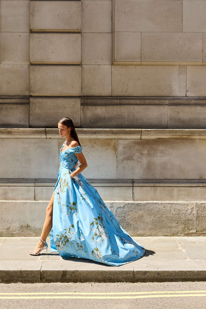Monique Lhuillier Fall 2026 Blue wisteria printed taffeta asymmetric off-the-shoulder draped ballgown with slit- lookbook. 