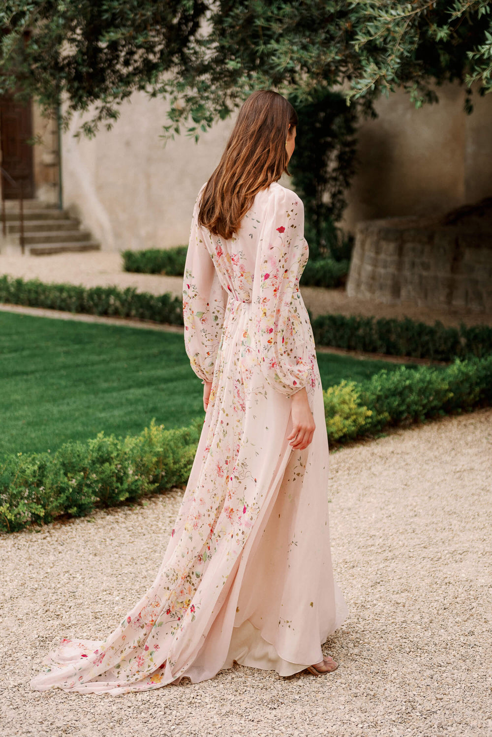 Monique Lhuillier Spring 2024 long sleeve gown with attached necktie and gathered waist in buff floral printed chiffon.