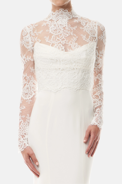 Silk white, long sleeve lace bridal jacket with high neck and hook eye closure at the back.  Shown over silk white satin gown - front crop.