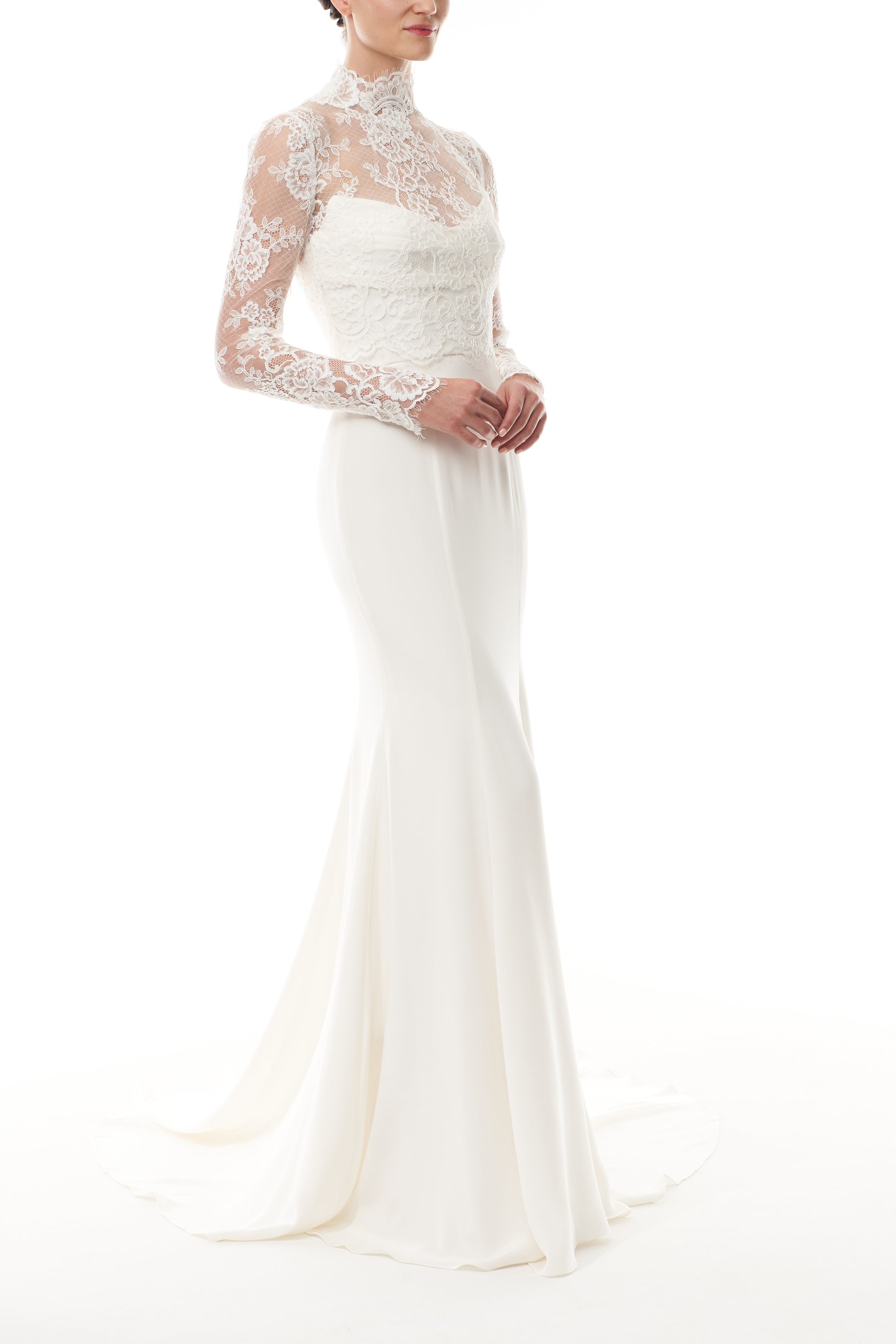 Silk white, long sleeve lace bridal jacket with high neck and hook eye closure at the back.  Shown over silk white satin gown - side.