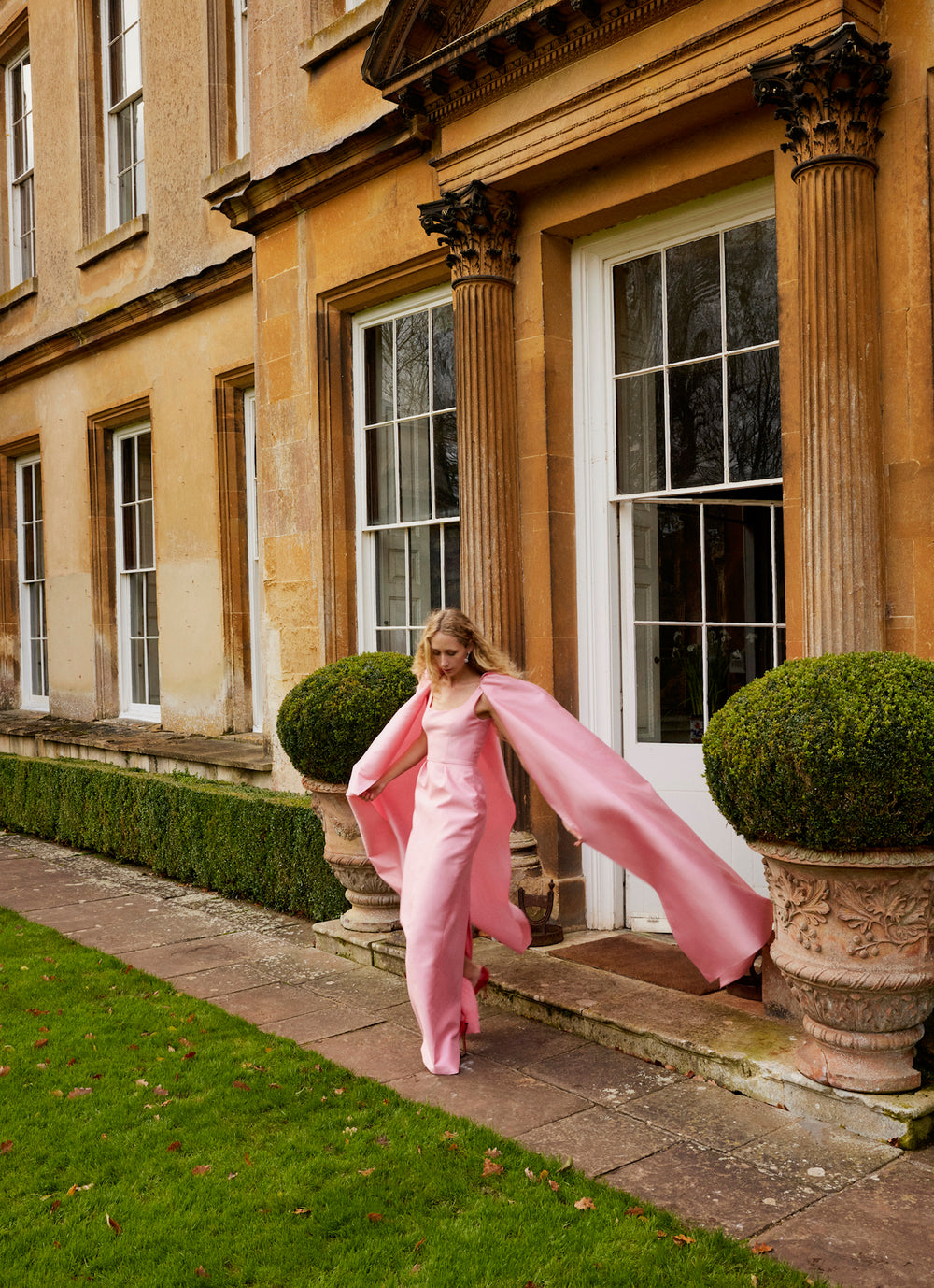 Monique Lhuillier Fall 2024 Dahlia pink mikado, sleeveless column gown with scoop neckline and attached cape - lookbook two.