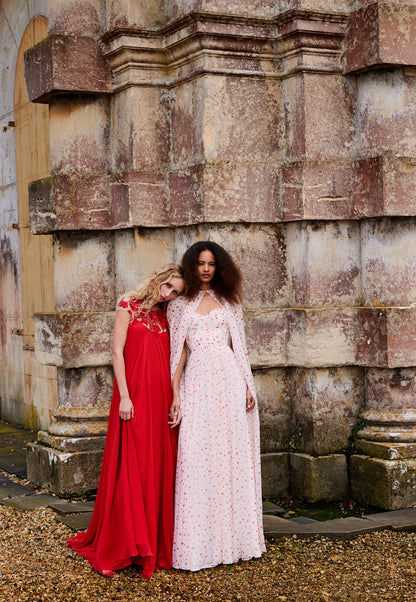 Monique Lhuillier Fall 2024 chiffon cape shown over the matching strapless gown with gathered sweetheart bodice in heart printed chiffon fabric - lookbook.