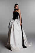 Monique Lhuillier Fall 2026 Noir/Silk White velvet and duchesse satin Strapless
dropped waist ball gown with floral
embellishment and scarf - lookbook.
