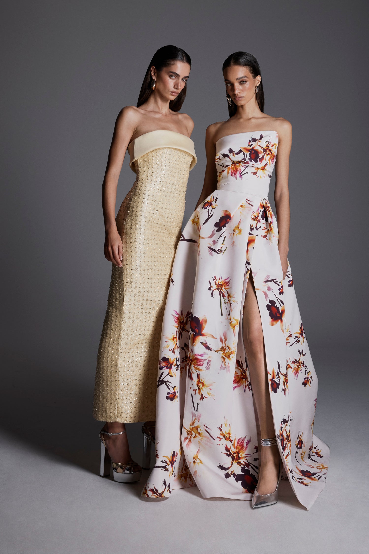 Monique Lhuillier Fall 2026: model on left wearing pale yellow embroidered strapless column gown; model on right wearing white/multi strapless floral printed ballgown with slit - lookbook.