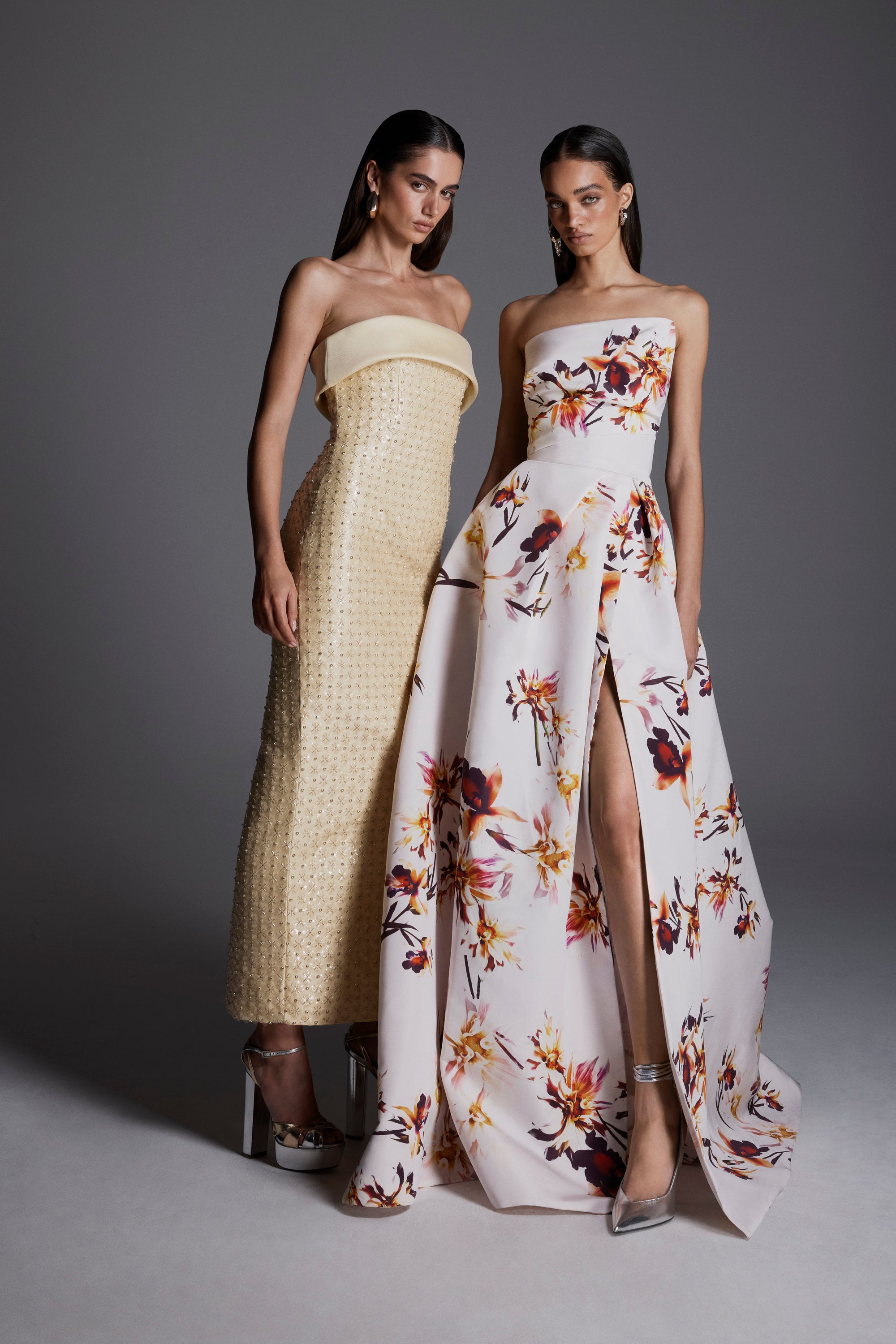 Monique Lhuillier Fall 2026: model on left wearing pale yellow embroidered strapless column gown; model on right wearing white/multi strapless floral printed ballgown with slit - lookbook.